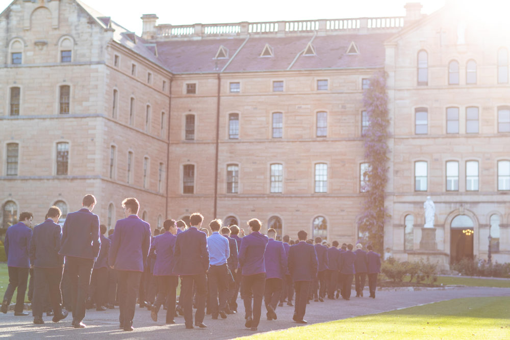 students walking towards sandstone building