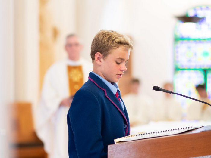 boy reading at podium in mass